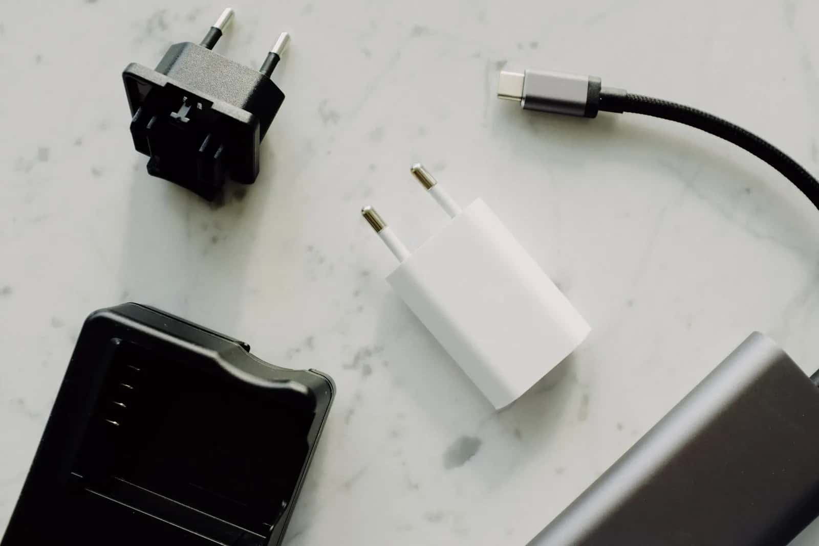 Adaptateur de voyage vers prise type G posé à côté de chargeurs français, à emporter à l'île Maurice