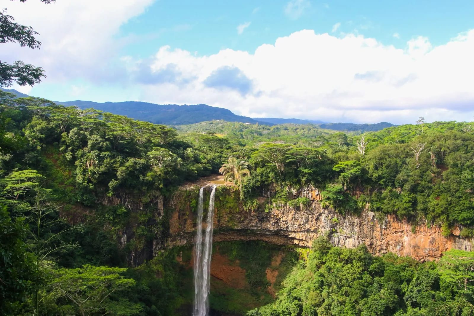 Chute de Chamarel en haut d'une falaise ocre, au-dessus de la forêt tropicale de l'île Maurice