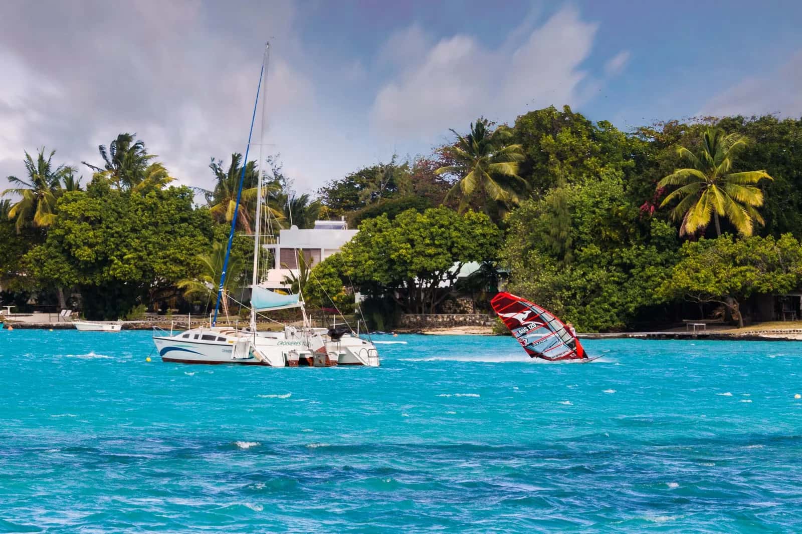 Catamaran et planche à voile dans le lagon turquoise face à Trou d'Eau Douce, point de départ des excursions vers l'Île aux Cerfs à l'île Maurice