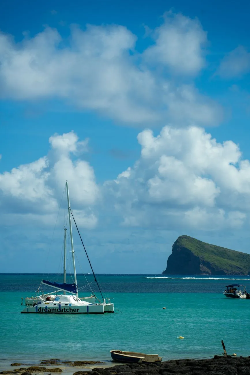 Catamaran d'excursion et l'îlot Coin de Mire vus depuis le rivage de Cap Malheureux