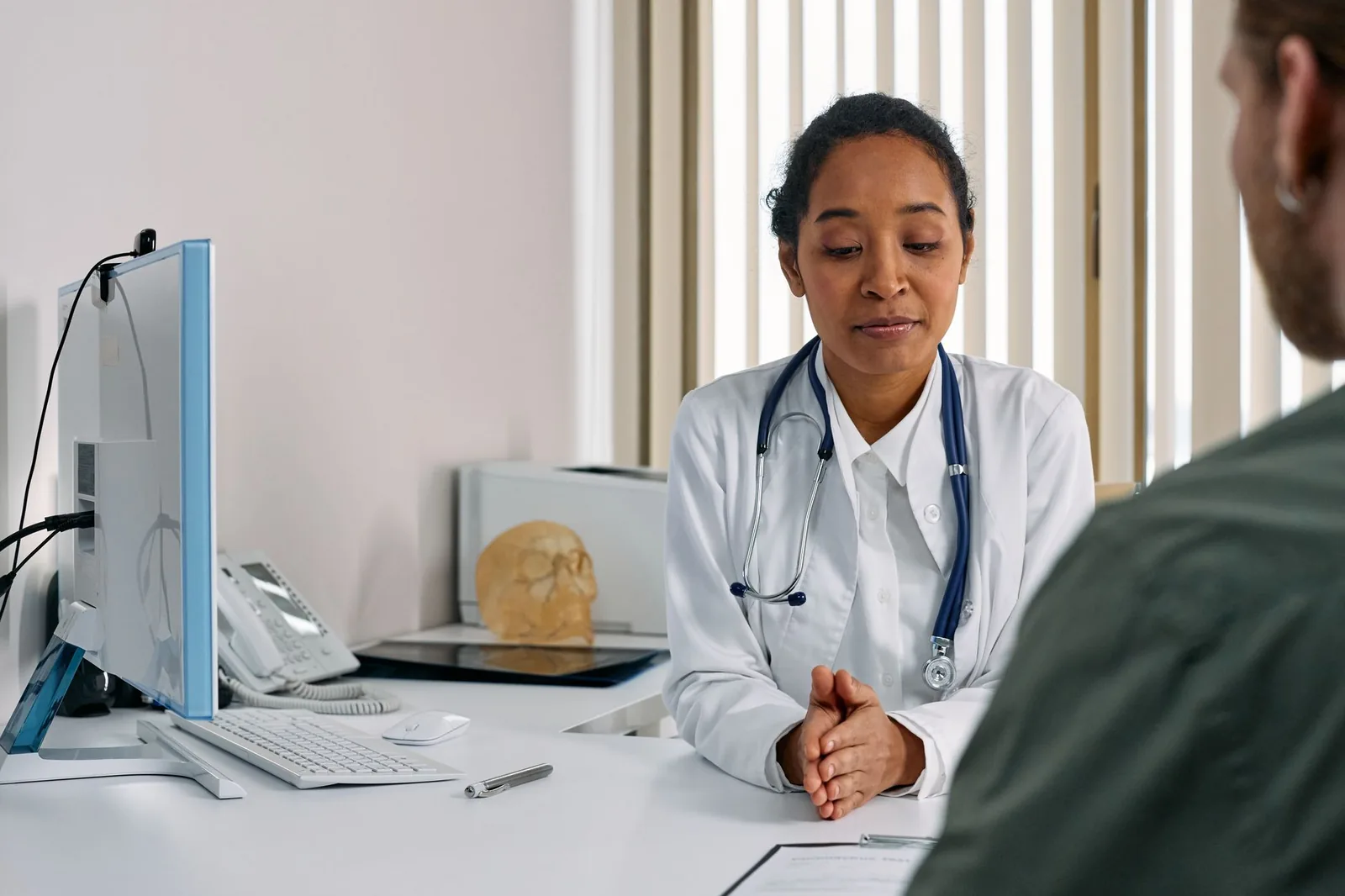Médecin généraliste en consultation avec un patient dans son cabinet