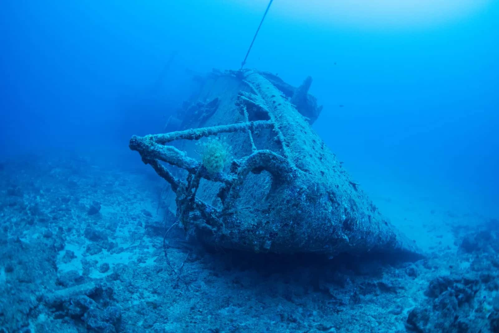Épave de navire posée sur un fond sableux dans une eau bleue et claire, comme le Stella Maru au nord de l'île Maurice