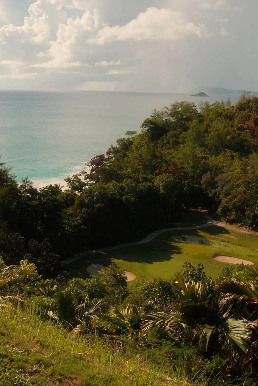 Parcours de golf entre collines boisées et plage, face à l'océan