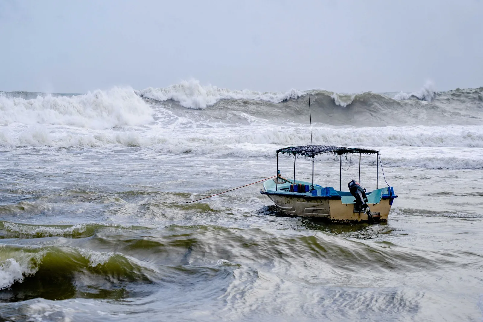 Petit bateau secoué par la houle sur une mer agitée