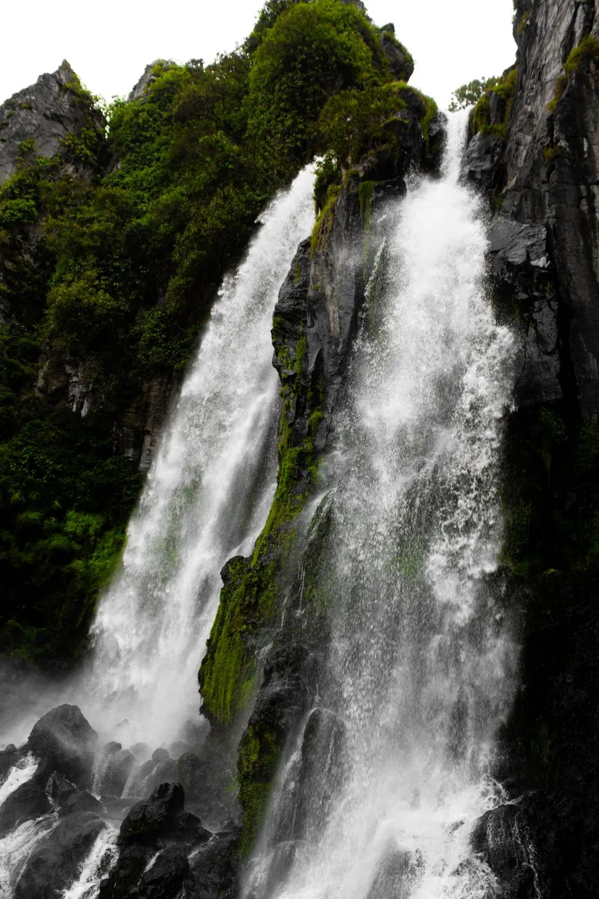 Deux chutes d'eau jumelles dévalant une paroi rocheuse couverte de mousse