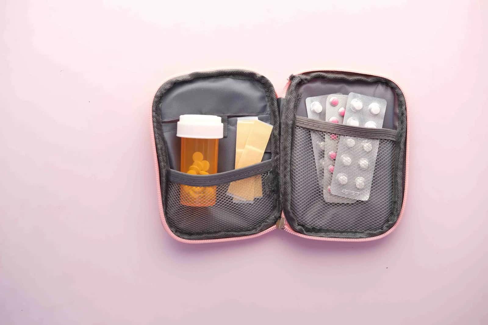 Trousse de pharmacie de voyage ouverte avec médicaments et pansements, préparée pour un séjour à l'île Maurice