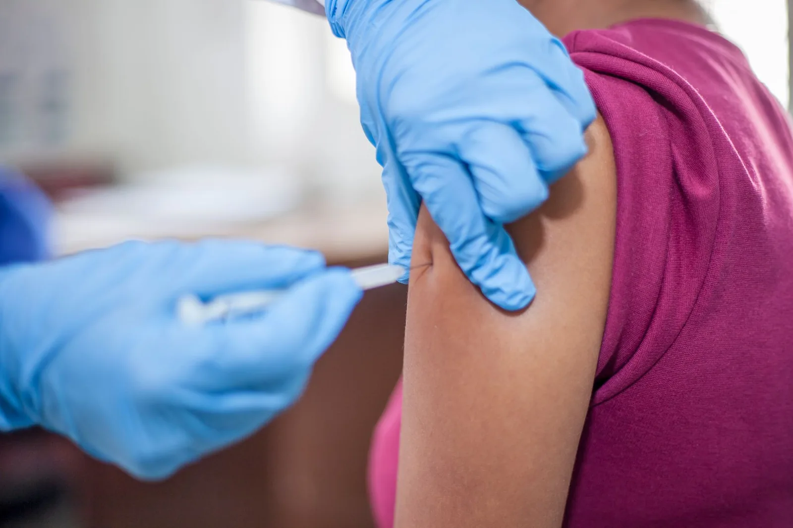 Injection d'un vaccin dans le bras d'une voyageuse avant un départ à l'île Maurice